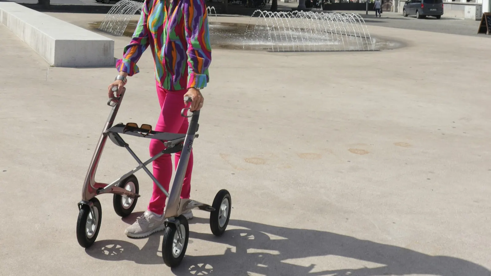 Oudere persoon gebruikt een rollator op een plein