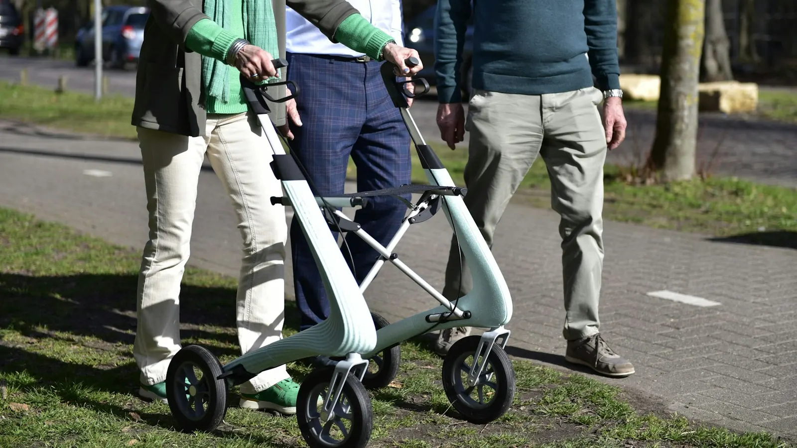 Oudere mensen wandelen buiten met een rollator